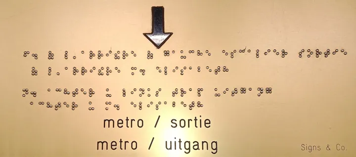 Photo d’origine : Plaque de signalisation bilingue français-néerlandais, avec son texte en braille gravé en relief.