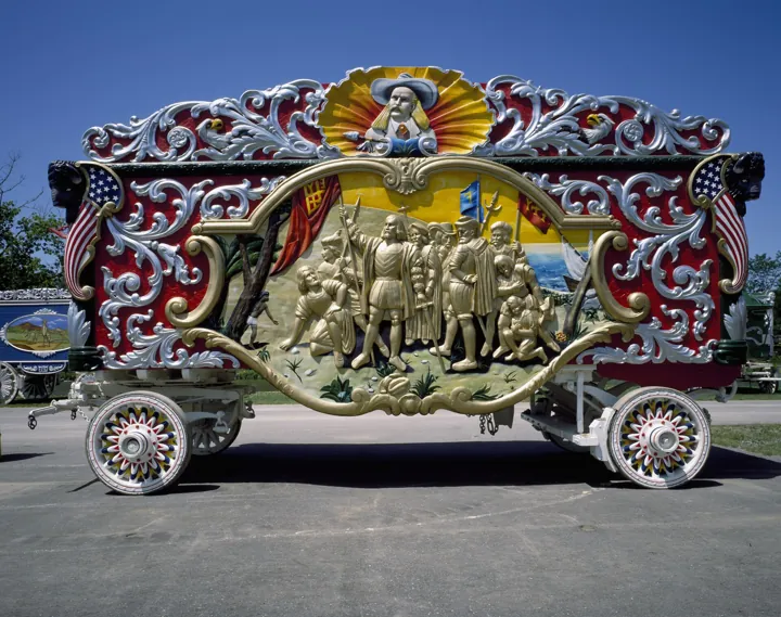 Photo d’origine : Char de parade de cirque (« bandwagon ») richement sculpté et peint, aux roues multicolores