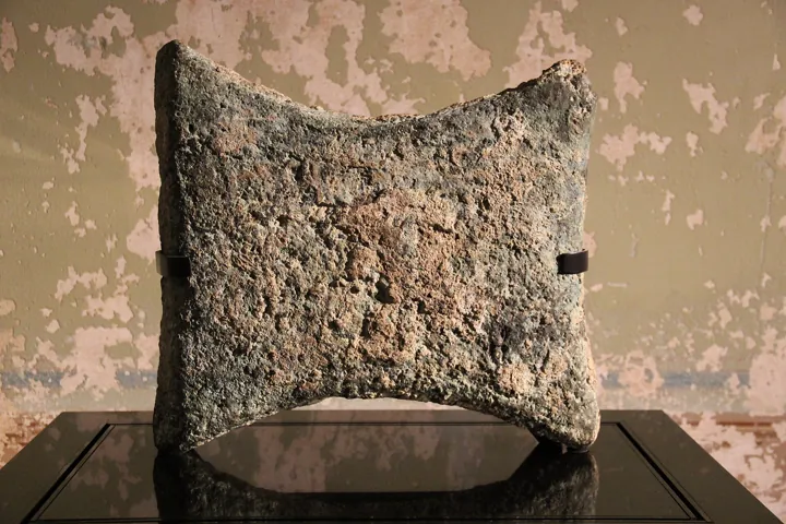 Photo d’origine : Un lingot de cuivre antique en forme de peau de bœuf, exposé dans un musée.