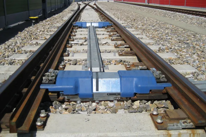 Photo d’origine : Aiguillage ferroviaire vu de près, où la voie se sépare en deux.