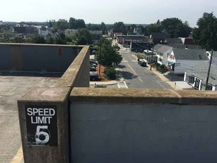 Photo d’origine : Panneau « Speed limit 5 » sur le muret d'un parking en hauteur : une limite fixée, mais qui a sa raison d'être.
