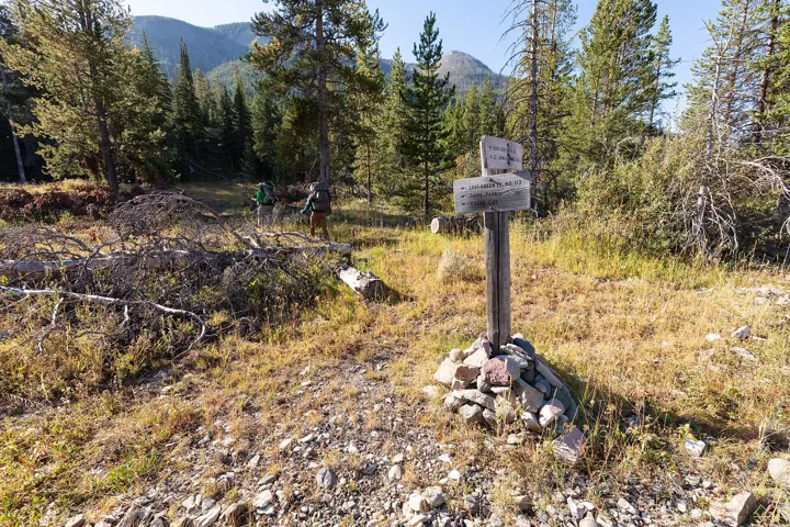 Photo d’origine : Poteau indicateur à un carrefour de sentiers en forêt, avec plusieurs destinations