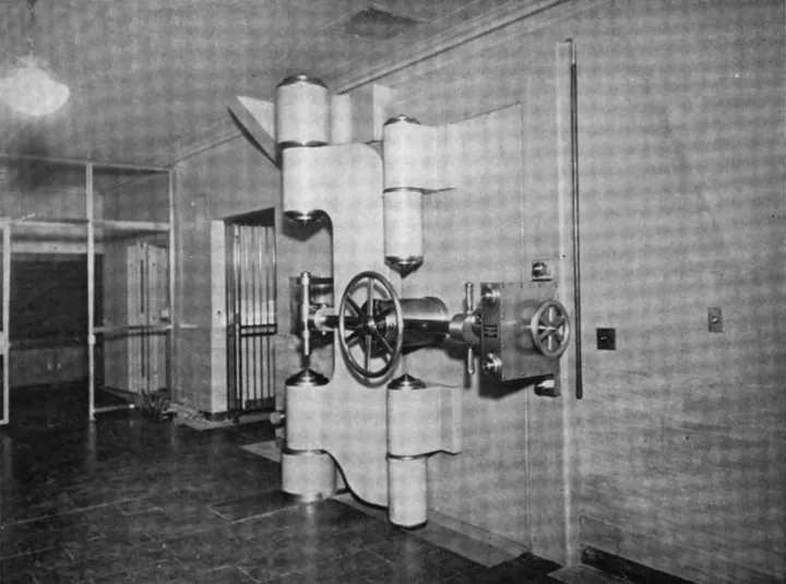 Photo d’origine : Porte de chambre forte d'une banque, avec ses gros verrous cylindriques et ses volants de manœuvre.